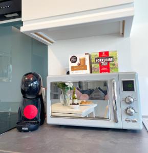 a microwave sitting on a kitchen counter with a robot inside at Elegant apartment in city center by HNFC Stays in Newcastle upon Tyne