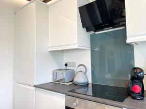a kitchen with white cabinets and a toaster at Elegant apartment in city center by HNFC Stays in Newcastle upon Tyne