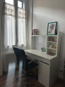 uma secretária com uma cadeira num quarto com uma janela em Appartamento centro storico Pordenone em Pordenone