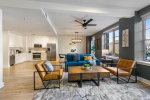 a living room with a blue couch and chairs at The Big Easy's Finest: 4-BR Luxury Condo in NOLA in New Orleans