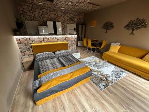 a bedroom with a large bed and a couch at Gold Downtown Apartman in Debrecen