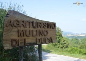 una señal en el costado de un camino de tierra en Agriturismo Mulino del Duca, en Urbino