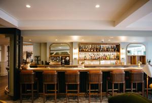 a bar with brown stools in a room at Hotel Emeline in Charleston