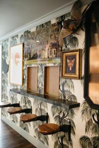 a wall with stools in a room with a mural at Hotel Emeline in Charleston