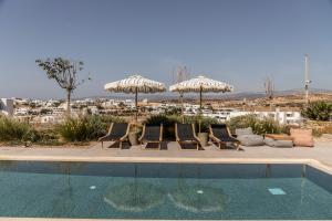 a group of chairs and umbrellas next to a pool at Nysis Koufonisia in Koufonisia