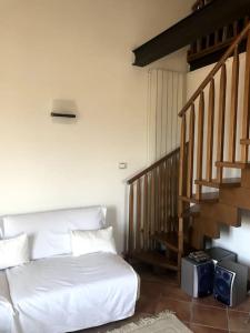 een slaapkamer met een wit bed en een trap bij Appartamento panoramico Terranera in Terranera