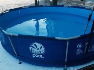 a blue pool with a reflection in the water at Guest House Šeperić in Jastrebarsko