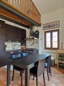 een keuken met een zwarte tafel en stoelen bij Appartamento panoramico Terranera in Terranera