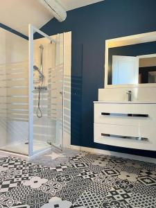 uma casa de banho com um chuveiro e uma parede azul em Studio du petit caillou en Drôme provençale em Saint-Restitut