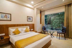 a hotel room with a bed and a large window at The Triana in Varanasi