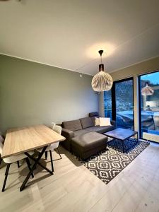 een woonkamer met een bank en een tafel bij Penthouse, Lerkendal, NTNU, free parking in Trondheim