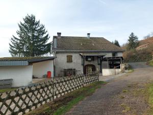 una casa con una valla al lado de una carretera en Ferme des boudieres en Fresse-sur-Moselle