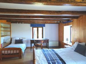 a bedroom with two beds and a desk in it at Ferme des boudieres in Fresse-sur-Moselle