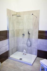 um chuveiro com uma porta de vidro na casa de banho em Palazzo 15 em Nápoles