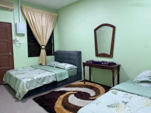 クアンタンにあるHomestay Kuantan Pantai Batu Hitam No14 L4のベッド2台と鏡のある寝室