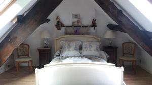 a bedroom with a large bed with two chairs at Le moulin des cavaliers in La Rouquette