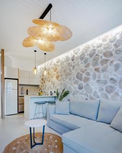 a living room with a blue couch and a kitchen at Pithea Luxury Living in Koroni