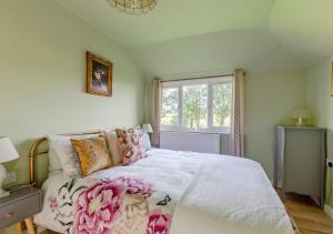 a bedroom with a large bed with flowers on it at Blossom Cottage in Lakenheath