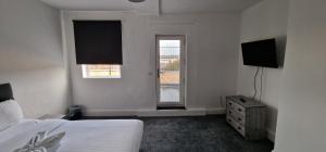 Schlafzimmer mit einem Bett, einem TV und einem Fenster in der Unterkunft APARTMENT IN CENTRAL BARNSLEY in Barnsley