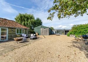 a yard with a patio and a house at Blossom Cottage in Lakenheath
