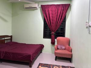 クアンタンにあるHomestay Pantai Batu Hitam Kuantan No14のベッドと椅子と窓のある寝室 +3枚の写真