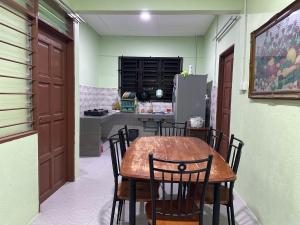 クアンタンにあるHomestay Pantai Batu Hitam Kuantan No14のキッチンにテーブルと椅子があるダイニングルーム