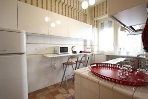 een keuken met een witte koelkast en een rode plaat op het aanrecht bij Corso Francia 1BR in Rome