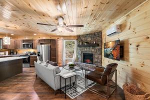 a kitchen and living room with a couch and a fireplace at Brand New Luxury Cabin-Private Appalachian Retreat in Gatlinburg