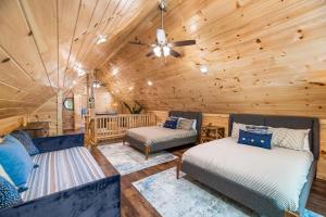 a log cabin with two beds and a ceiling fan at Brand New Luxury Cabin-Private Appalachian Retreat in Gatlinburg