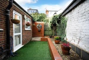 a small backyard with a green lawn at Ivy Cottage in Henley on Thames