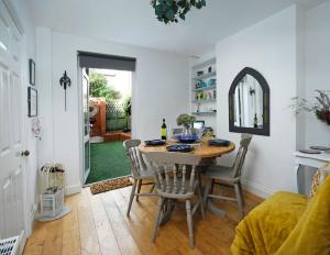 a dining room with a table with chairs and a mirror at Ivy Cottage in Henley on Thames