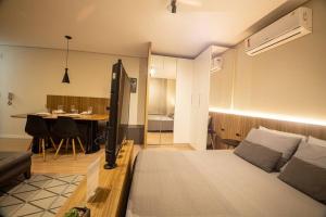 een slaapkamer met een bed en een eetkamer met een tafel bij Studio 309 Parque Una + garagem in Pelotas