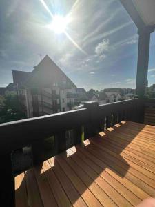 d'un balcon avec une terrasse en bois bien exposée. dans l'établissement Le Balbec - Appartement Cosy, à Cabourg