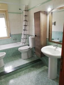 墨西拿的住宿－IL POSTO GIUSTO，浴室设有2个卫生间、水槽和浴缸。