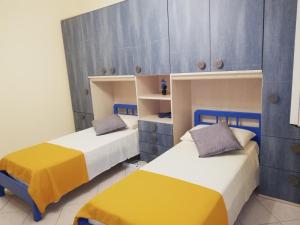 twee bedden in een kamer met blauw en geel bij IL POSTO GIUSTO in Messina