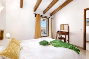 a bedroom with a bed with a green hat on it at Duplex flat in the old town of Alcudia in Alcudia