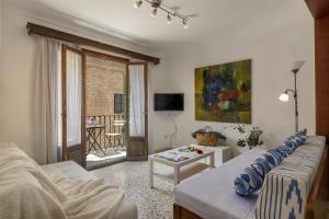 a living room with a couch and a table at Duplex flat in the old town of Alcudia in Alcudia