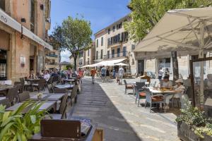 a street with tables and chairs and people sitting at tables at Duplex flat in the old town of Alcudia in Alcudia