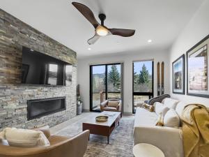 a living room with a stone wall and a ceiling fan at 541 Center Circle 3Br 3,5Ba townhouse in Silverthorne