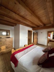 ein Schlafzimmer mit einem großen Bett und Holzdecken in der Unterkunft Chalet Le Pery in Châtillon-sur-Cluses