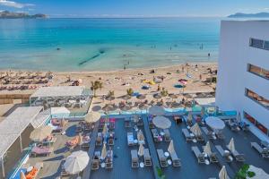 eine Luftansicht auf einen Strand mit Stühlen und Sonnenschirmen in der Unterkunft The Sea Hotel by Grupotel - Adults Only in Can Picafort