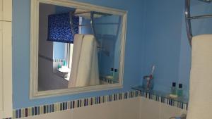 a mirror in a bathroom with a shower curtain at Chimneys B&B in Ipswich +36 photos