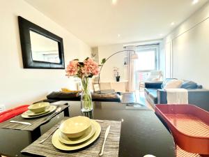 a living room with a vase of flowers on a table at AirScape Warm & Cosy Two Bed Apt in Birmingham