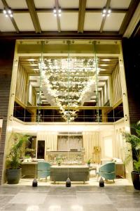 a lobby with a large glass wall with a chandelier at BluSalzz Residence Amritsar in Amritsar
