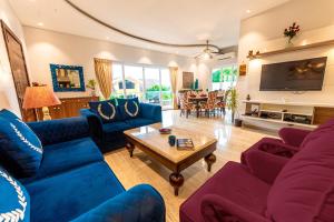 a living room with blue couches and a table at Infinity Villa, 5BHK-Private Pool-Caretaker, Baga in Baga