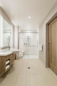 een witte badkamer met een wastafel en een douche bij SpringHill Suites St. Paul Downtown in Saint Paul