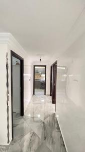Cette chambre est dotée de murs blancs et d'un sol en marbre. dans l'établissement Tetouan Relax Apartement, à Tetouan