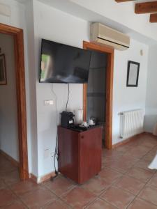 ein Wohnzimmer mit einem Flachbild-TV an der Wand in der Unterkunft Casa Rosa in Alcalalí