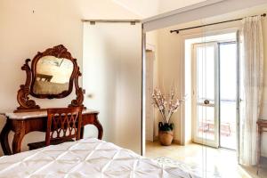 ein Schlafzimmer mit einem großen Spiegel und einem Bett in der Unterkunft Casa del pozzo sulla spiaggia in Cetara