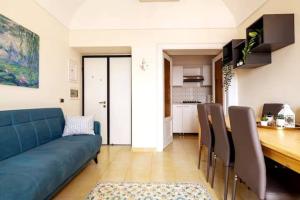 ein Wohnzimmer mit einem blauen Sofa und einem Tisch in der Unterkunft Casa del pozzo sulla spiaggia in Cetara